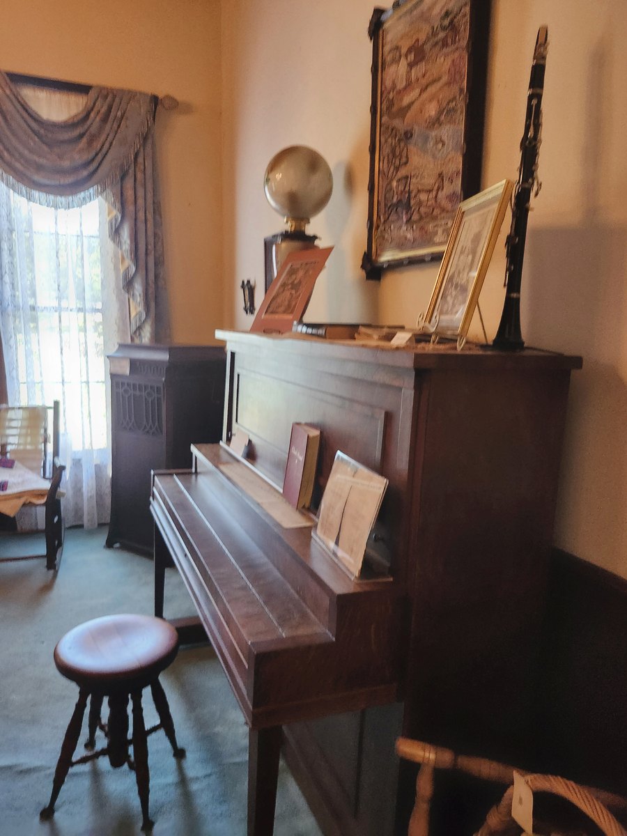 An upright piano and antiques in the museum parlor