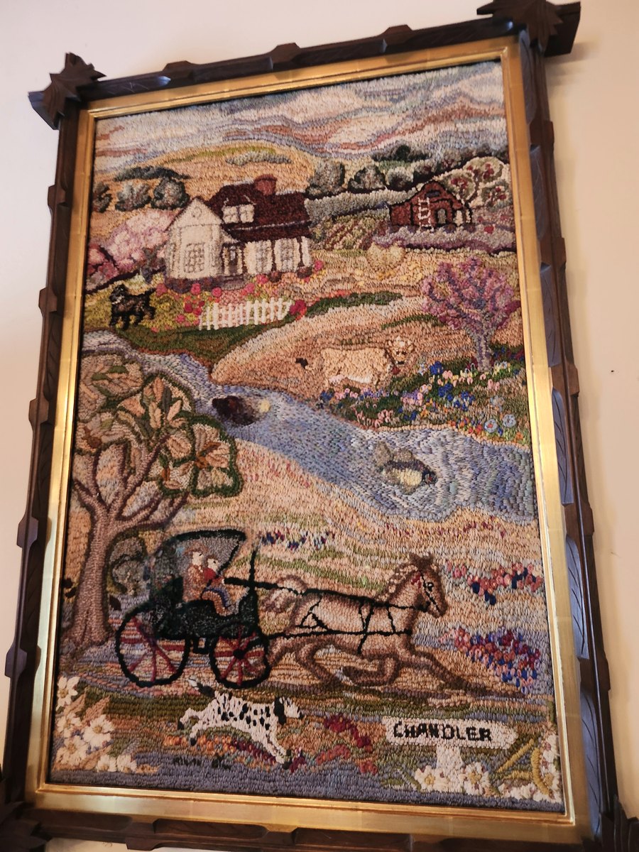 Framed folk-art textile showing the house, a river with a duck and the word Chandler