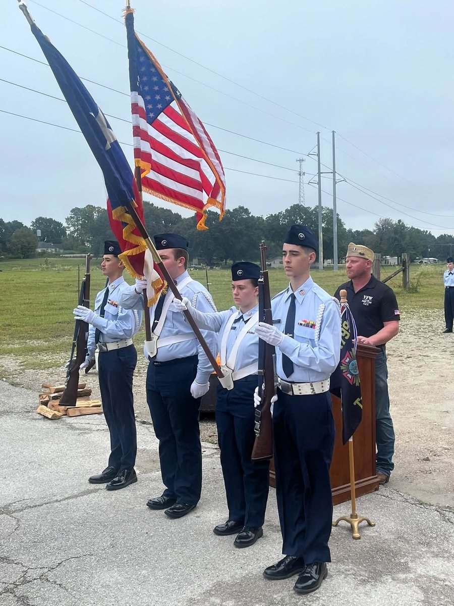 Civil Air Patrol cadets stand at attention with the Texas and U.S. flags beside a podium at the flag retirement ceremony in Tyler