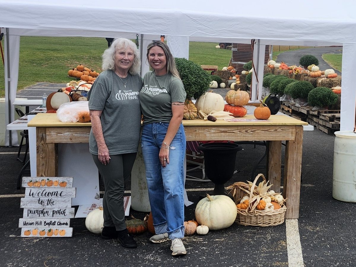 Pumpkin Park director Jennifer Harville, right, and volunteer Reba welcome guests at the front tent