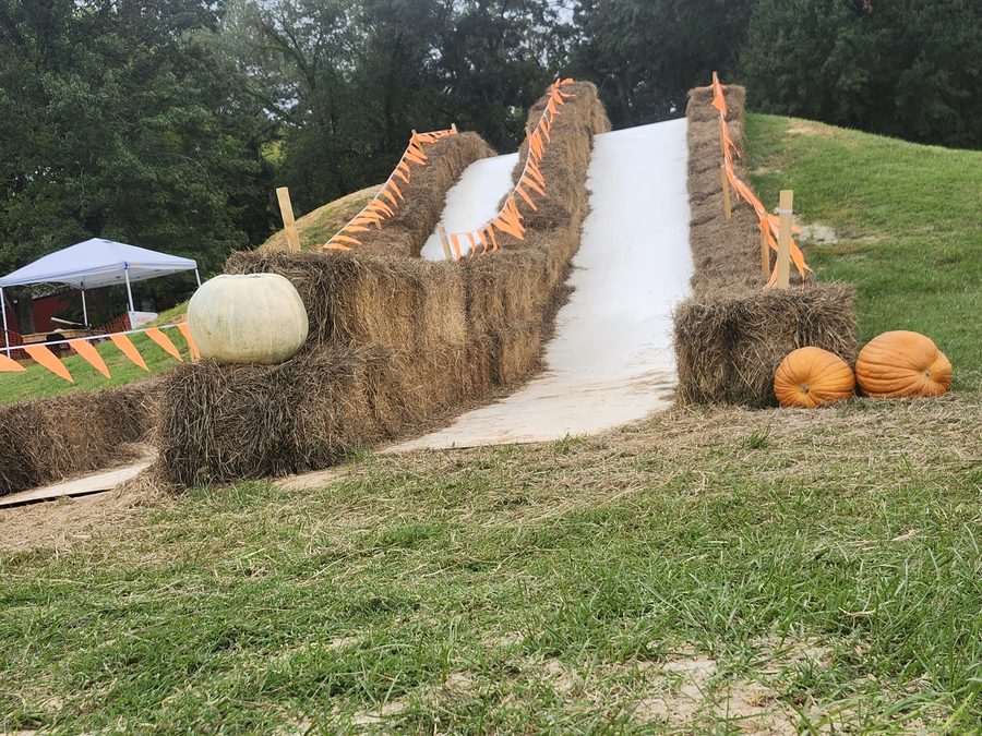 Hay bales and pumpkins line the two side-by-side lanes of the Pumpkin Peak Slide