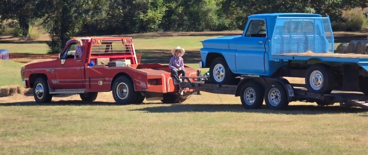 Jennifer Harville’s boys help unload the Pumpkin Park Truck, a 1964 Chevy that her husband, Gray, built and painted for the park